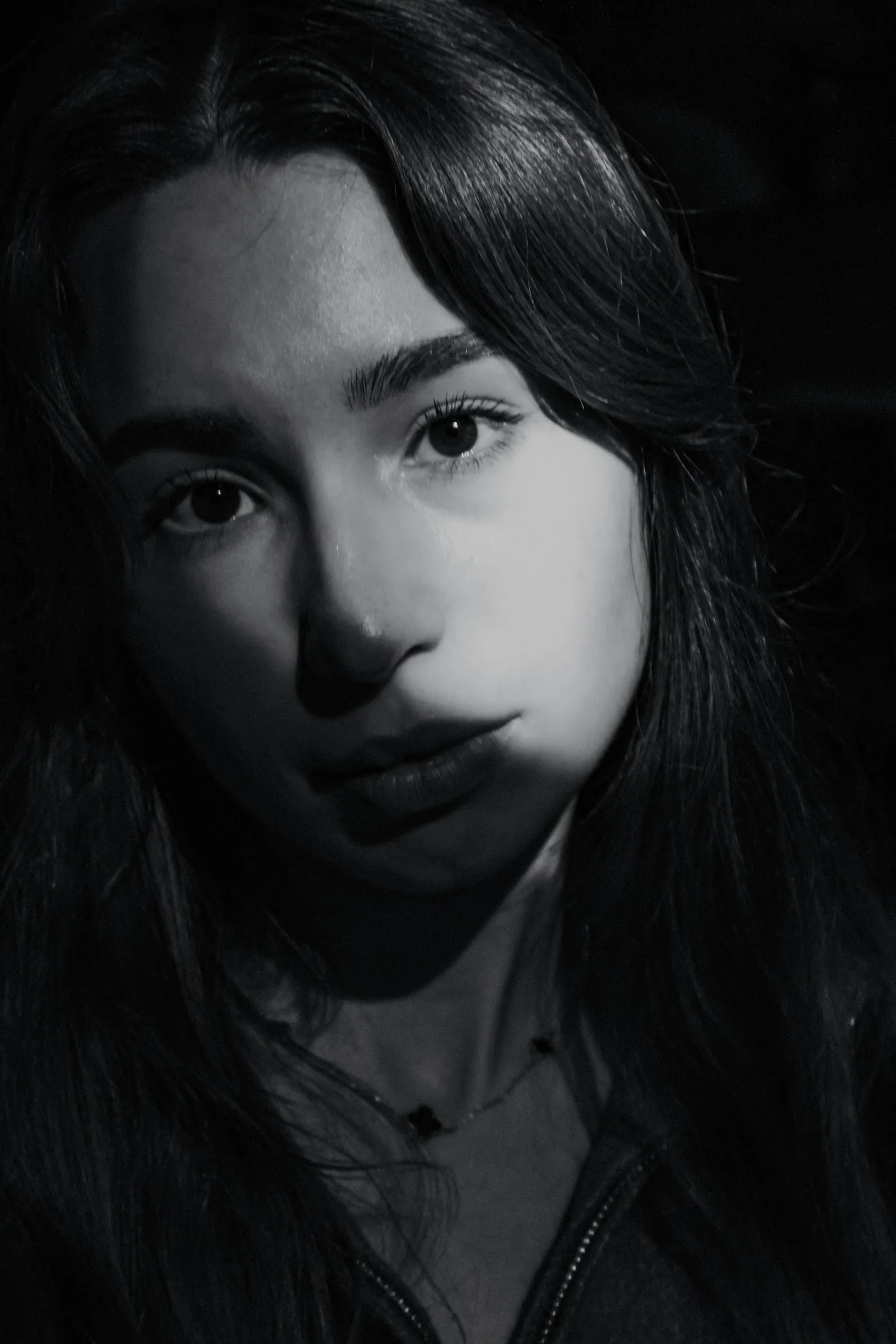 Portret feminin în alb și negru, cu lumină și umbre expresive. Imagine demonstrativă.