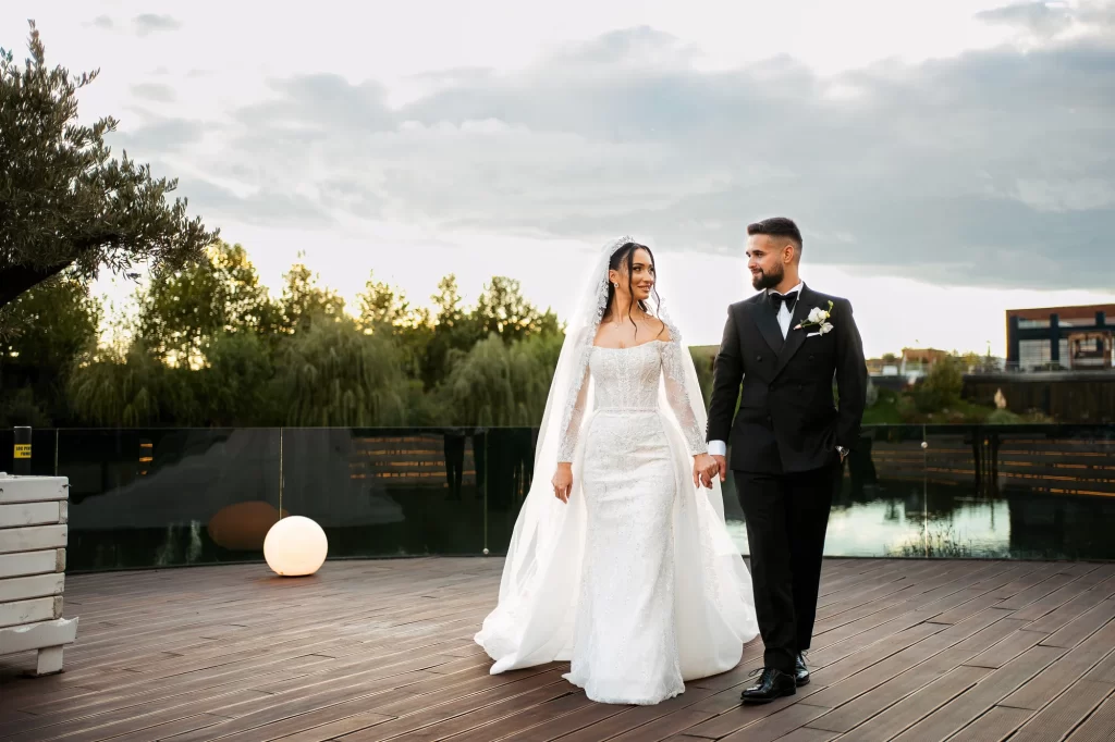 Bianca & Ștefan — Mirii mergând împreună lângă lac.