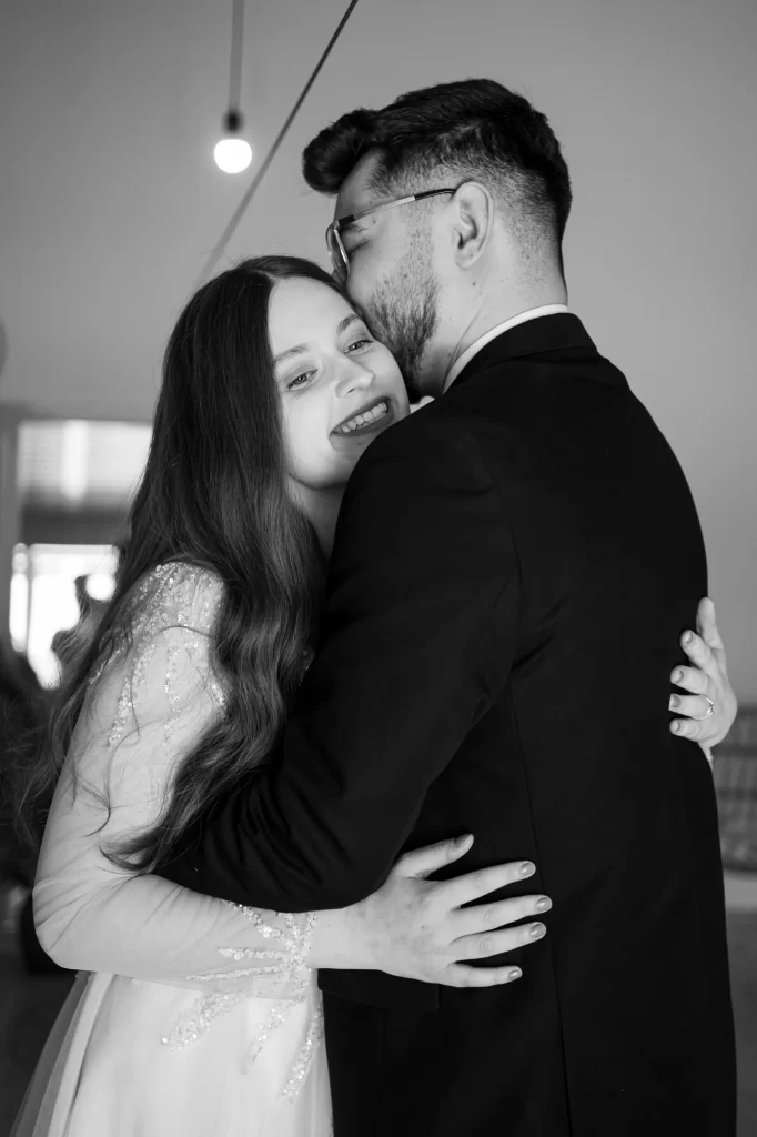 Mihaela & Mihai — Îmbrățișare spontană în alb-negru cu zâmbet convingător.