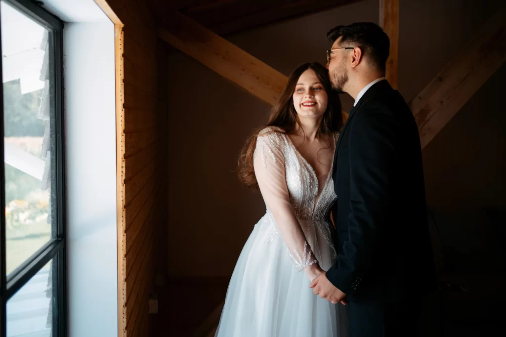 Mihaela & Mihai — Zâmbet luminos al miresei lângă fereastră.