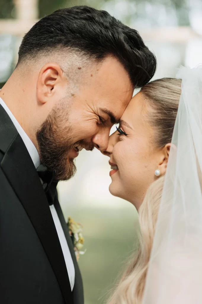Miruna & Ionuț — Prim-plan apropiat cu zâmbete naturale și priviri coborâte.
