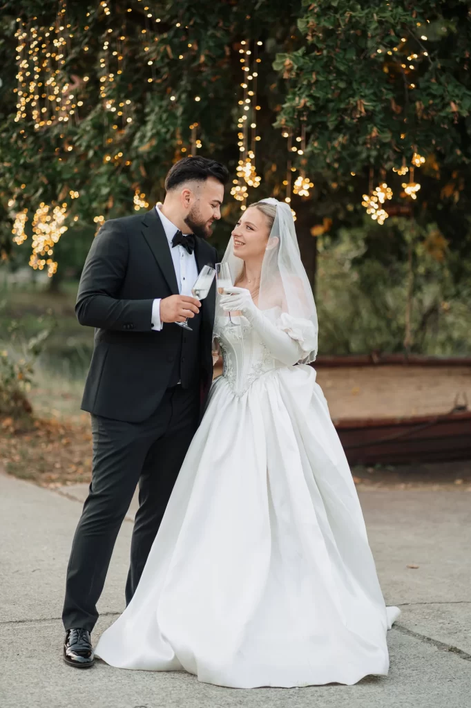 Miruna & Ionuț — Închidere cu un toast al cuplului la lumina caldă.