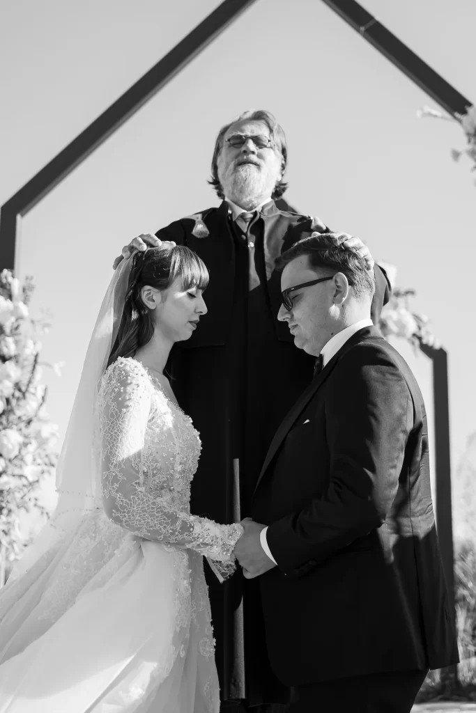 Raluca & Marius — Binecuvântarea cu mâinile preotului deasupra mirilor.