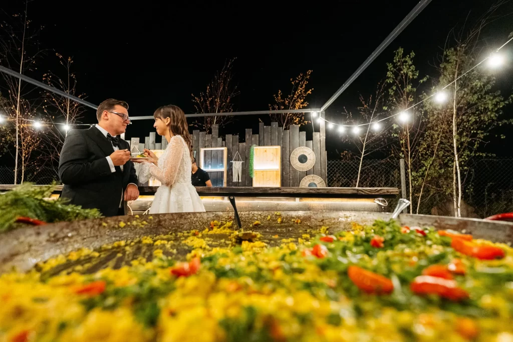 Raluca & Marius — Mirii degustă lângă preparatul festiv.