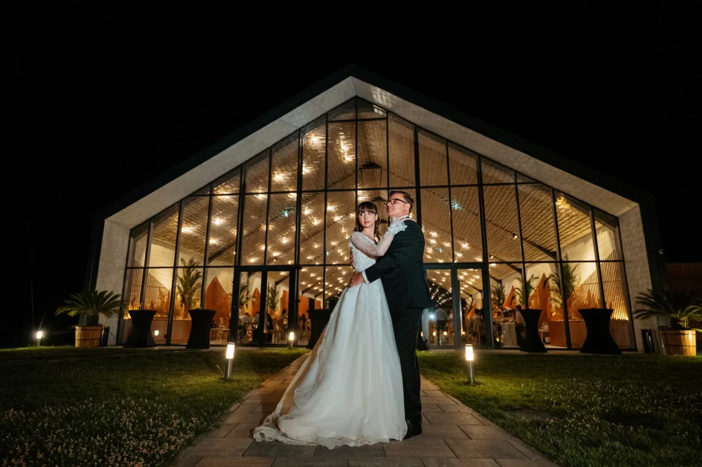 Raluca & Marius — Portret de noapte cu fațada iluminată.