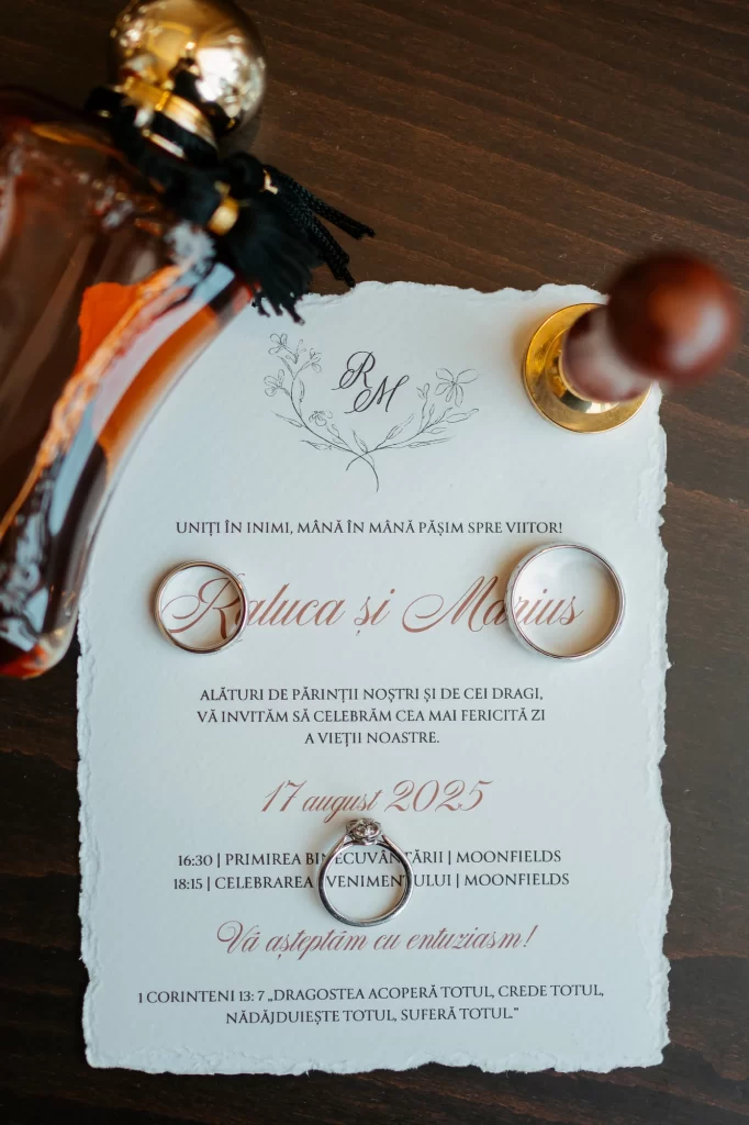 Invitația de nuntă Raluca și Marius, alături de verighete și inelul de logodnă.
